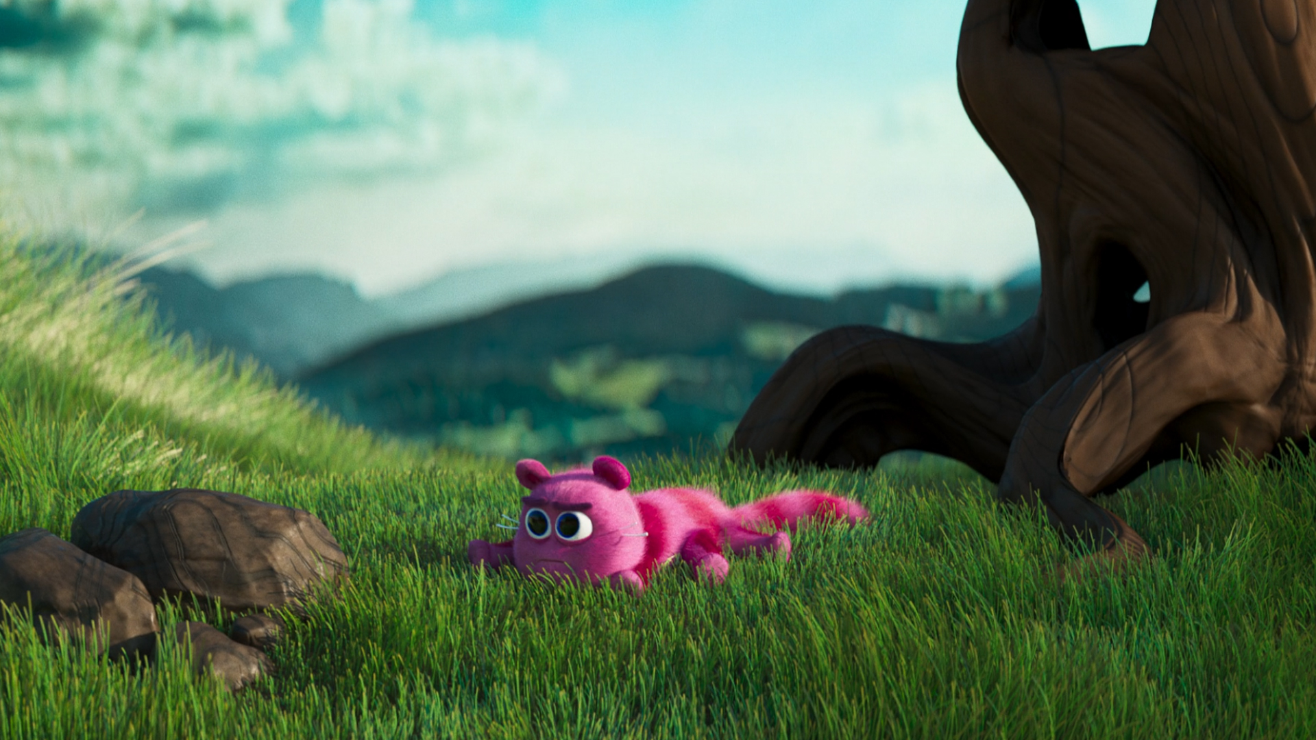 Skwoosh lands flat on the ground in soft green grass. Threes and mountains in the background.