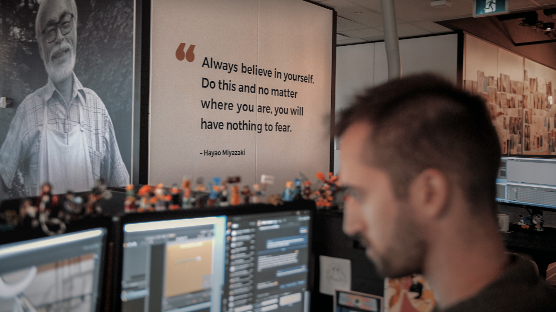 An animator from Mercury Filmworks works on his computer as a quote from Hayao Miyazaki is displayed in the background.