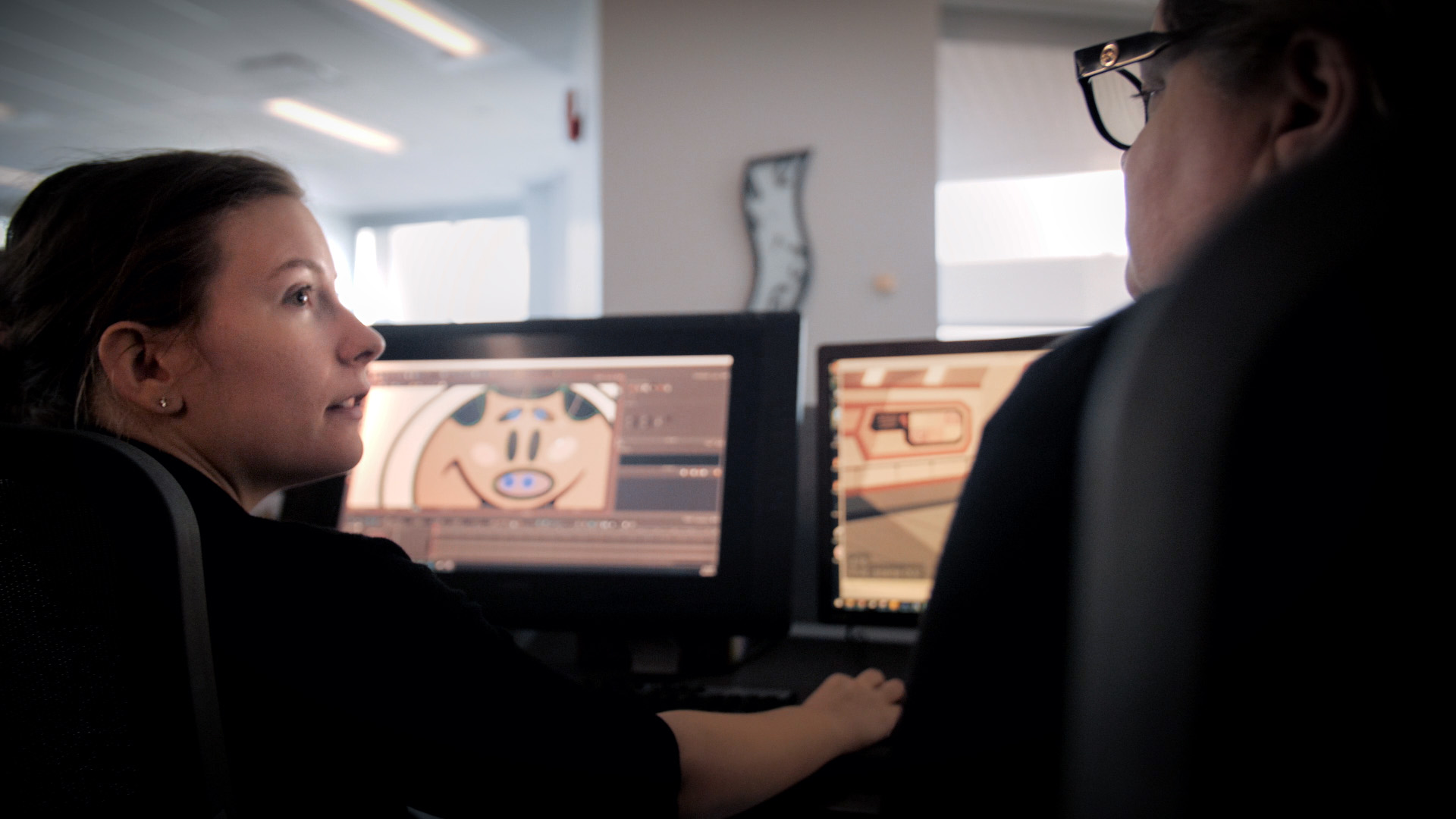 An Animator and her Supervisor from Mercury Filmworks look at each other talking as they look over a cintiq.